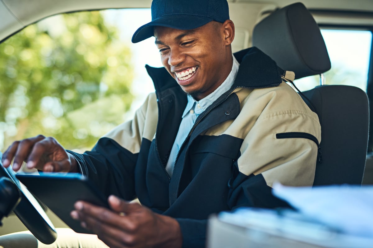 delivery man sitting in van and smiling