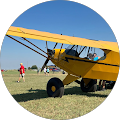 yellow propellor plane in a field